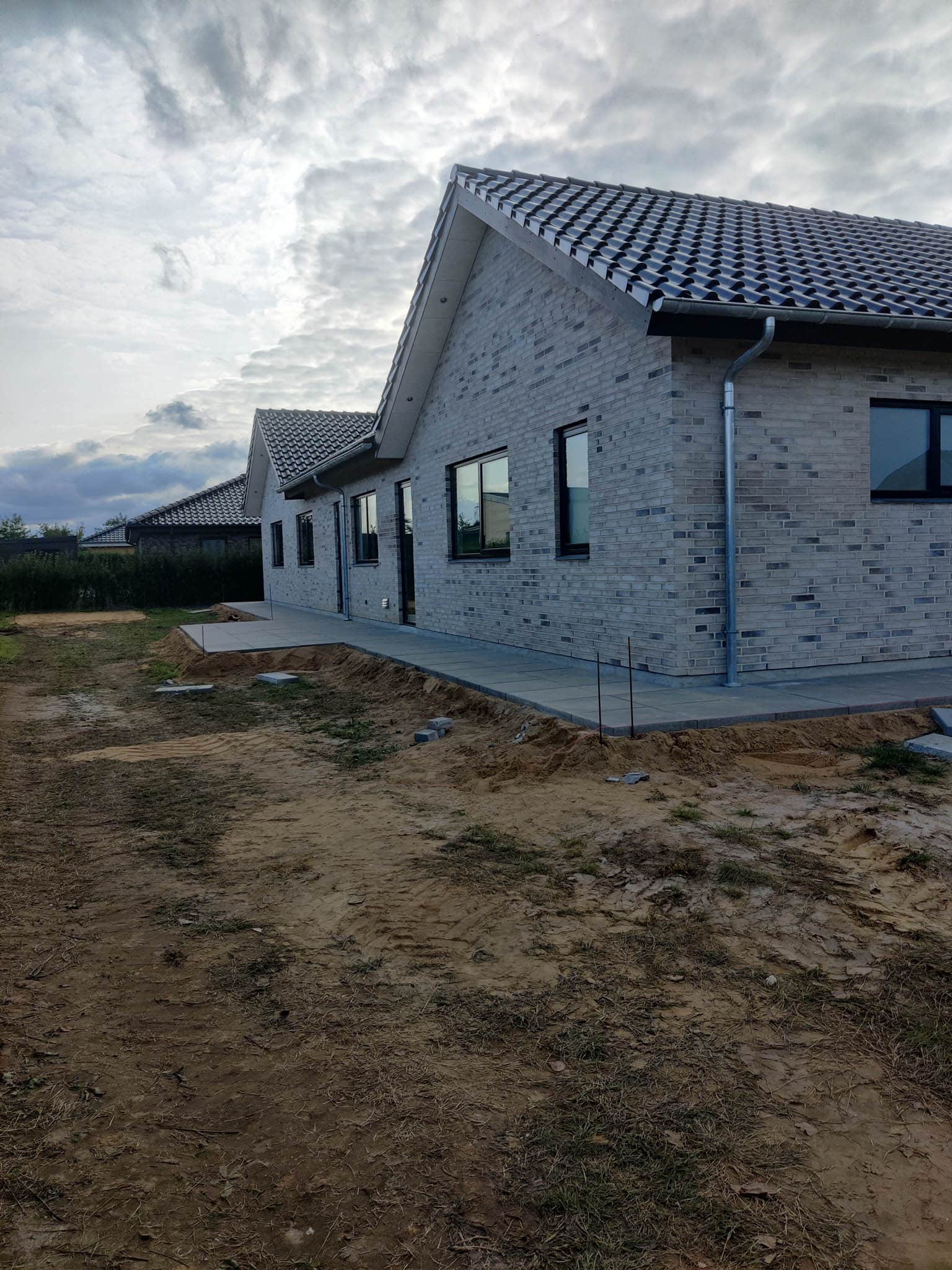 fliser lagt omkring huset og udgravning til terrasse